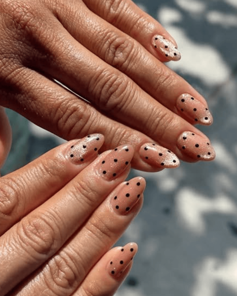Close up of a nude and polka dot velvet manicure